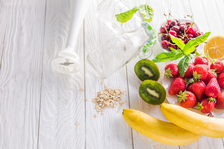 Cooking fruity smoothie on wooden table. Healthy eating. Organic foodの写真素材