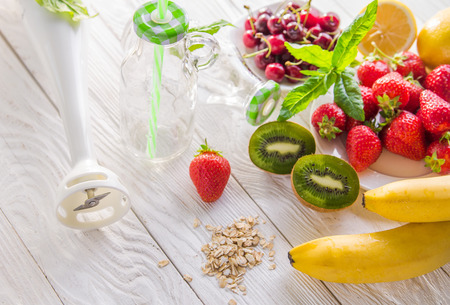 Cooking fruity smoothie on wooden table. Healthy eating. Organic foodの写真素材