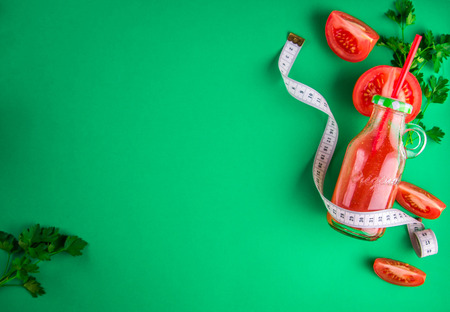 Tomato juice in the bottle on green background. Healthy eating conceptの写真素材