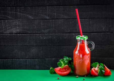Tomato juice on black wooden background. Healthy drink. Spaceの写真素材