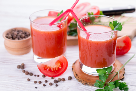 Tomato juice in glasses on white wooden background. Bloody Maryの写真素材