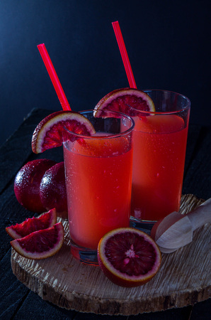 Homemade blood orange juice on black background. Refreshing summer cocktailの写真素材