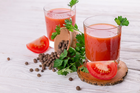 Tomato juice in glasses on white wooden background. Bloody Maryの写真素材