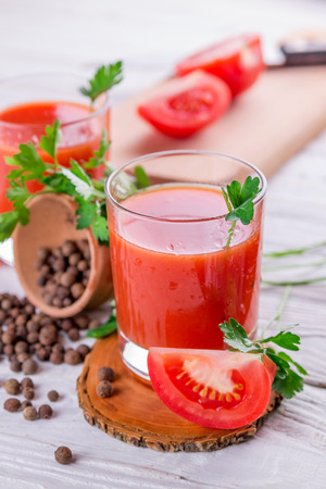 Tomato juice in glasses on white wooden background. Bloody Maryの写真素材