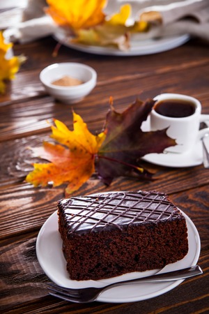 Chocolate brownie with a cup of coffee on wooden background. Autumn mood and cozinessの写真素材