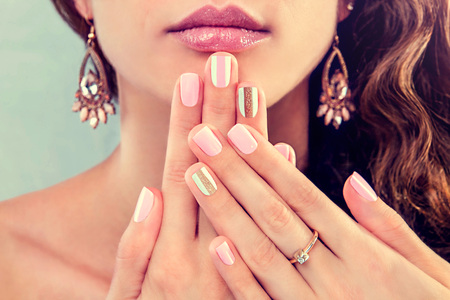 Beautiful woman with fresh manicure and makeup wearing jewellery. Beauty fashion model showing her nailsの写真素材