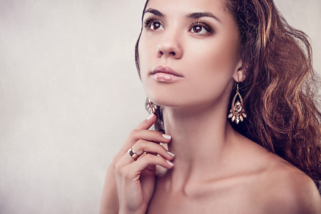 Beautiful woman with curly hair and manicure on grey backgroundの写真素材