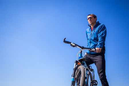 Young bicyclist against the blue sky. Active lifestyleの写真素材