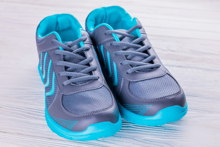Blue and grey sneakers on wooden background. Sportive shoesの写真素材