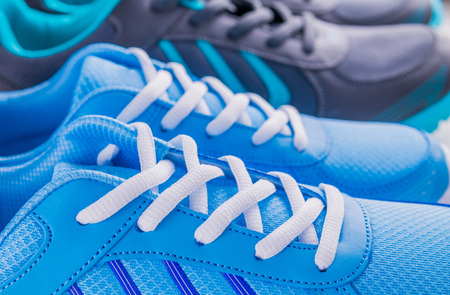 Two pairs of sneakers on wooden backgroundの写真素材