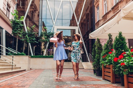Outdoor portrait of two young beautiful women walking on city street. Best friends hanging, having fun and relaxing together. Friendshipの写真素材