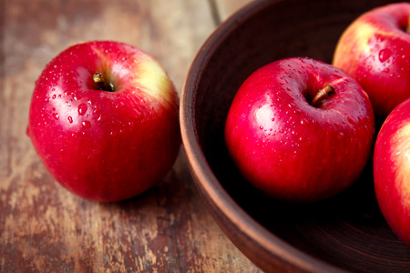 Ripe fresh red apples in bowl on wooden background. Autumn harvestの写真素材