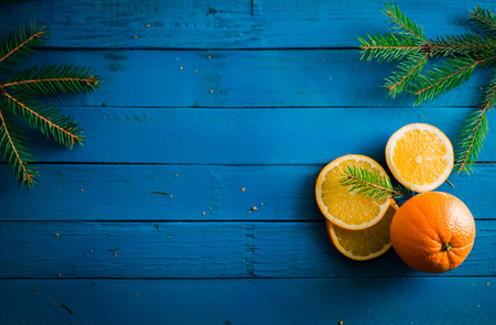 Sliced oranges on decorated with fir tree on blue wooden backgroundの写真素材