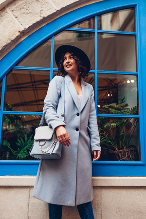 Beautiful young woman wearing stylish autumn outfit. Outdoor portrait of fashion model on city streetの写真素材