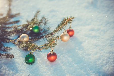 Fir branch decorated with toys on snow. Christmas backgroundの写真素材