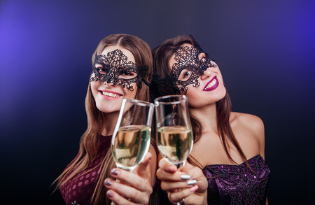 Girls celebrating New Year's eve drinking champagne on masquerade party in the clubの写真素材