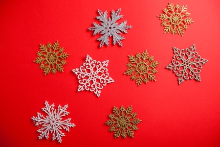 Red Christmas and New Year background with silver and golden snowflakes. Holiday symbol