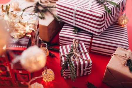 Christmas and New Year background. Gift boxes decorated with fir branches on red background