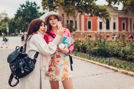 Two women tourists taking picture of architecture in Odessa. Happy friends travelers going sightseeingの写真素材