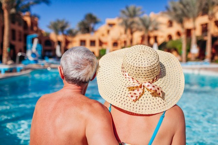 Senior couple relaxing by swimming pool. People enjoying vacation. Valentines dayの写真素材