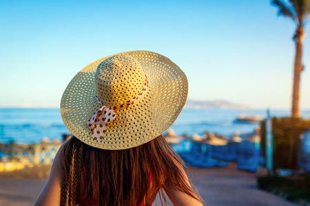 Portrait of young woman in hat walking on Red sea beach. Summer vacationの写真素材