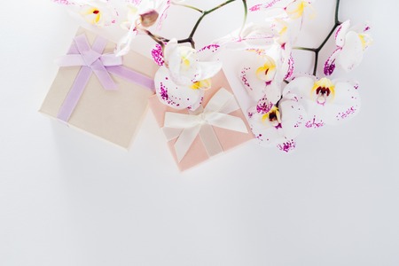 Gift boxes with orchid on white background. Presents for Valentine's day with flowersの写真素材