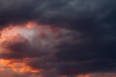 Dark grey cloudy sky background at sunset. Natural texture