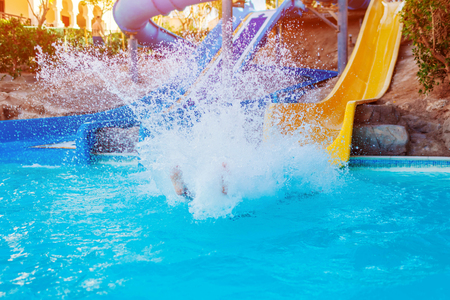 Senior woman having fun on water slide in hotel aquapark. Summer vacationの写真素材