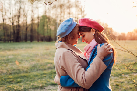 Happy senior mother and her daughter hugging in spring forest at sunset. Mother's day concept. Family valuesの写真素材