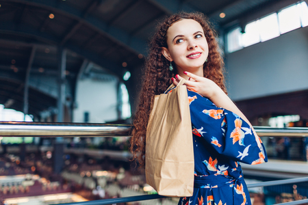 Young happy woman holding shopping paper bags in shopping center. Purchasesの写真素材