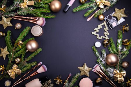 Christmas sale of cosmetics and brushes. Set of cosmetics and tools with Christmas decoration on black background.の写真素材