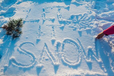 Let it snow writing on fresh snow made by woman outdoors. Winter frosty cold weather. Top viewの写真素材