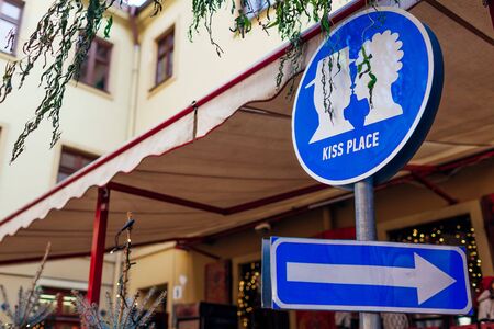 Kiss place sign in Lviv outdoor cafe. Kissing couple picture and arrow. Traveling and tourism, ukrainian places of interestの写真素材