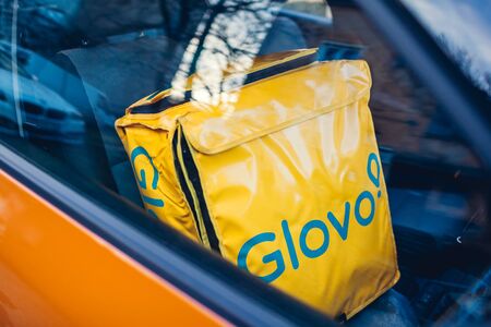 Lviv, Ukraine- January 13, 2020: Glovo delivery bag in car. Spain food delivery companyのeditorial素材