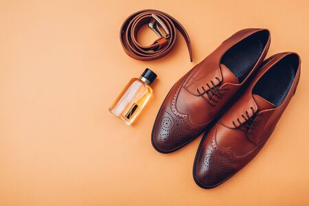 Oxford male brogues shoes with accessories. Men's fashion. Classical brown leather footwear with belt and perfume. Top viewの写真素材