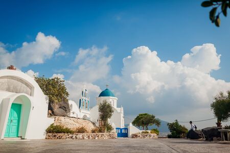 Santorini traveler exploring discovering greek church architecture in Akrotiri. Man hiker having...
