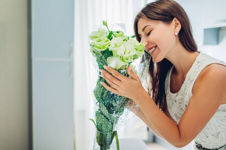 Woman smelling bouquet of eustoma flowers.の写真素材