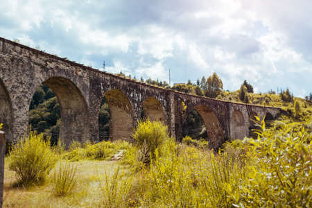 Viaduct railway bridge in Vorokhta. Ancient architecture landmark. Trip to Carpathian summer mountains in Ukraine. Travelingの写真素材