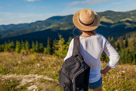 Trip to Carpathian mountains. Happy woman tourist hiking enjoying wild nature landscape. Traveling in summer Ukraineの写真素材