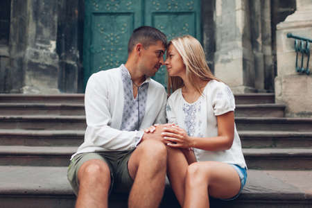 Couple in love walking in old Lviv city wearing traditional ukrainian shirts. Happy people relax by dominican cathedral holding handsの写真素材