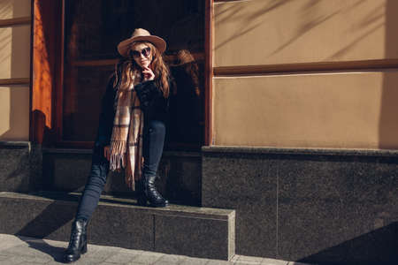Street portrait of stylish woman wearing autumn clothes and accessories outdoors. Female fashion. Spaceの写真素材
