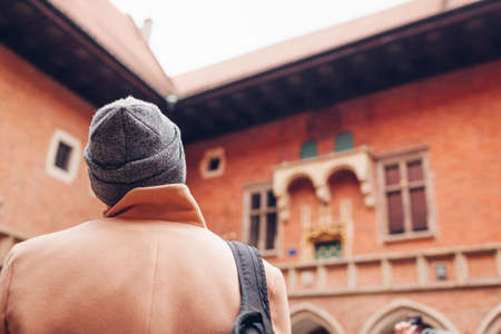 Man tourist enjoying excursion in Medieval Jagiellonian University, Collegium Maius, Krakow, Poland. Travel around Europeの写真素材