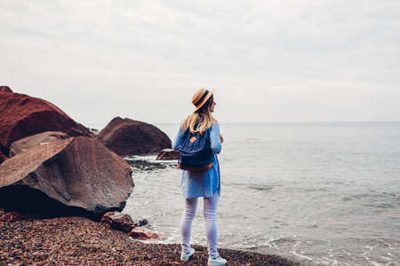 Woman traveler walking enjoying Red beach in Santorini island, Greece. Tourist admiring sea landscape. Tourism, summer travelingの写真素材