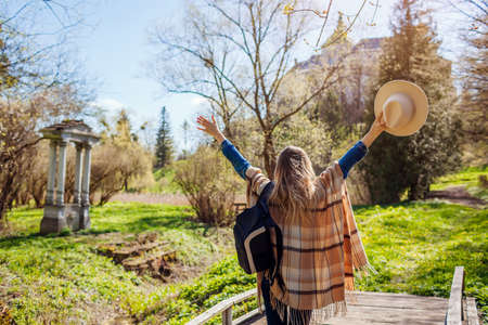 Happy tourist woman visiting Olesko Castle raising arms admiring view of ancient architecture. Travelling in Western Ukraine.の写真素材
