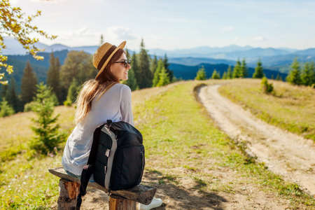 Trip to Carpathian mountains. Woman tourist hiking and relaxing admiring landscape. Traveling around spring Ukraineの写真素材
