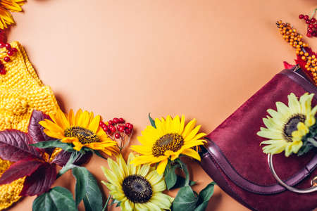 Autumn fall female fashion in orange yellow red colors with sunflowers. Sweater with burgundy purse. Clothes and accessories. Sale and shoppingの写真素材
