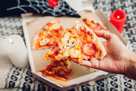 Helloween pizza with little paper jack-o-lantern pumpkins. Holiday party with candles and costumes.の写真素材