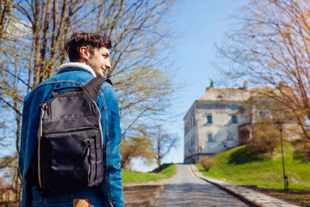 Tourist backpacker visiting Olesko Castle in autumn. Trip to Western Ukraine. Traveler enjoys fall...