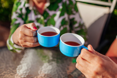 Senior family couple drinking tea in cafe. People enjoying beverages outdoors. Close-up of cupsの写真素材
