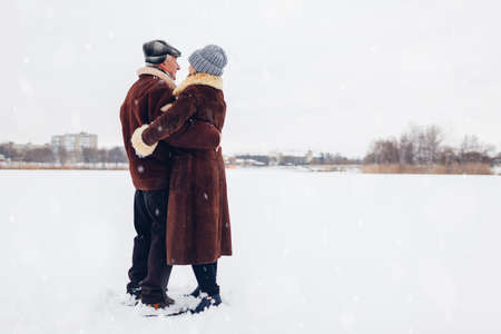 Senior family couple dancing outdoors during snowy winter weather. Elderly people having fun. Valentines dayの写真素材